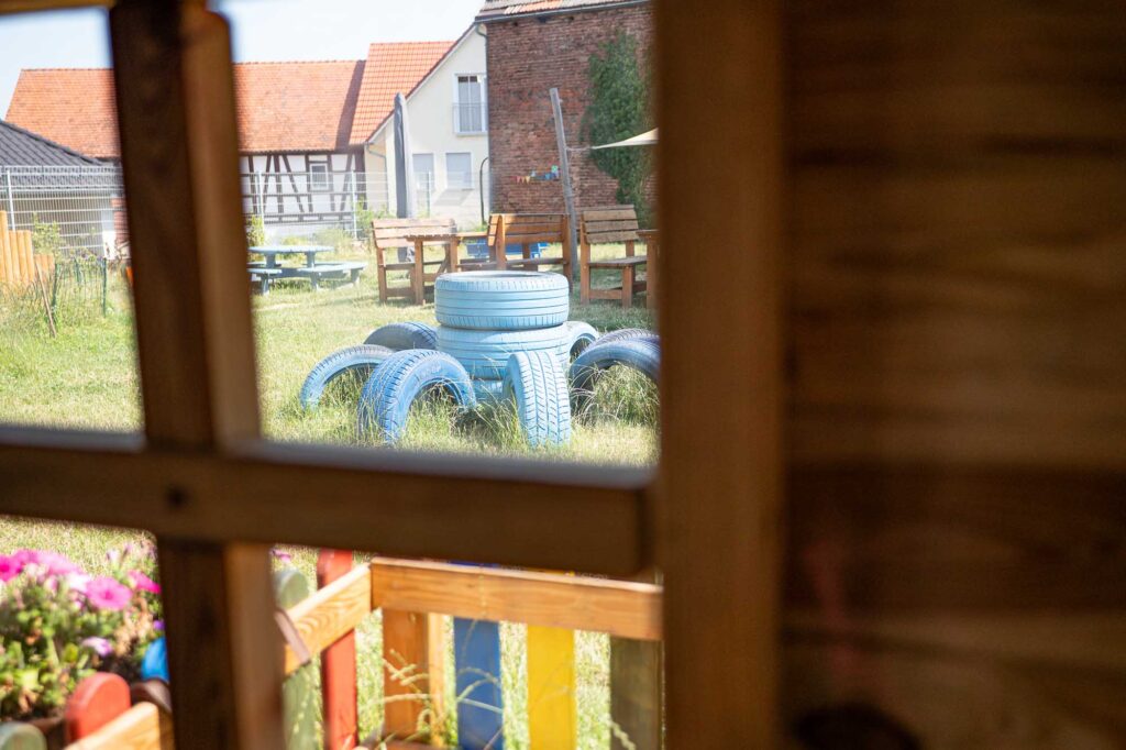 Blick aus dem Spielhaus auf blaue Reifen